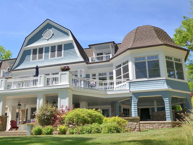 home exterior painting in light blue with white railings